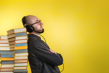Education and modern technologies. The concept of audio books. A man in glasses, shirt, and...