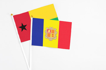 Andorra and Guinea Bissau stick flags on white background. High quality fabric, miniature national flag. Peaceful global concept.White floor for copy space.