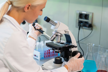 Scientist working in lab. Female doctor making medical research. Laboratory tools: microscope, test tubes, equipment. Biotechnology, chemistry, science, experiments and healthcare.