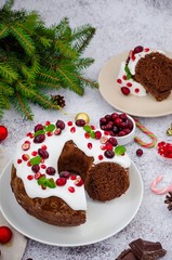 Chocolate cake Christmas wreath with sugar icing, cranberries, pomegranate and mint leaves on top. Festive Dessert for Christmas and New Year.