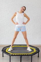 girl engaged in fitness on the mini trampoline . perform exercises on the trampoline.A slim...