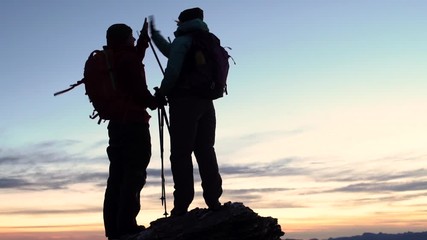 Silhouette hikers celebrating achieving ambition Lake Wakatipu Queenstown