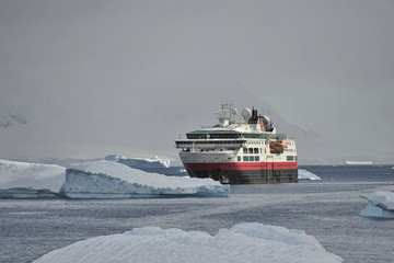 Cruise ship between icebergs in Antarctica.