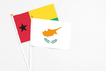 Cyprus and Guinea Bissau stick flags on white background. High quality fabric, miniature national flag. Peaceful global concept.White floor for copy space.