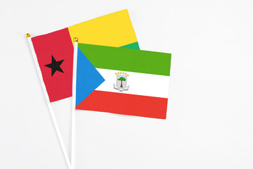 Equatorial Guinea and Guinea Bissau stick flags on white background. High quality fabric, miniature national flag. Peaceful global concept.White floor for copy space.