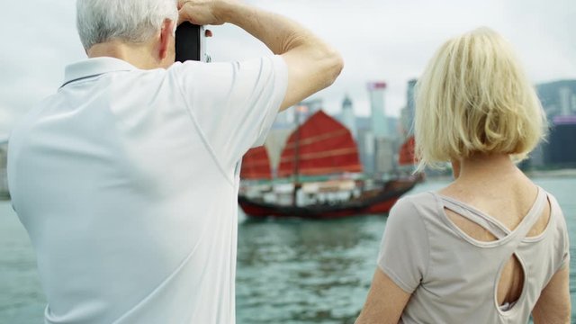 Caucasian senior couple taking photographic pictures Hong Kong 