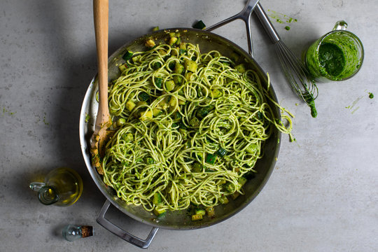 Overhead view of spaghetti with zucchini, parsley pesto and bottarga