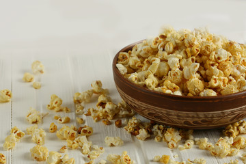 Salt popcorn on the wooden table, selective focus. Horizontal. Copy space.