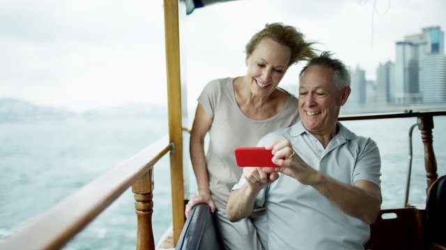 Caucasian senior couple holding cell phone Hong Kong 