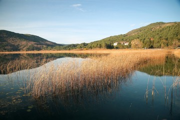Wooden Lake house inside forest in Bolu Golcuk National Park, Turkey with reflection on the lake on cloudy sky.