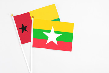 Myanmar and Guinea Bissau stick flags on white background. High quality fabric, miniature national flag. Peaceful global concept.White floor for copy space.