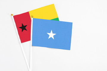Somalia and Guinea Bissau stick flags on white background. High quality fabric, miniature national flag. Peaceful global concept.White floor for copy space.