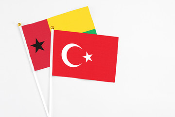 Turkey and Guinea Bissau stick flags on white background. High quality fabric, miniature national flag. Peaceful global concept.White floor for copy space.