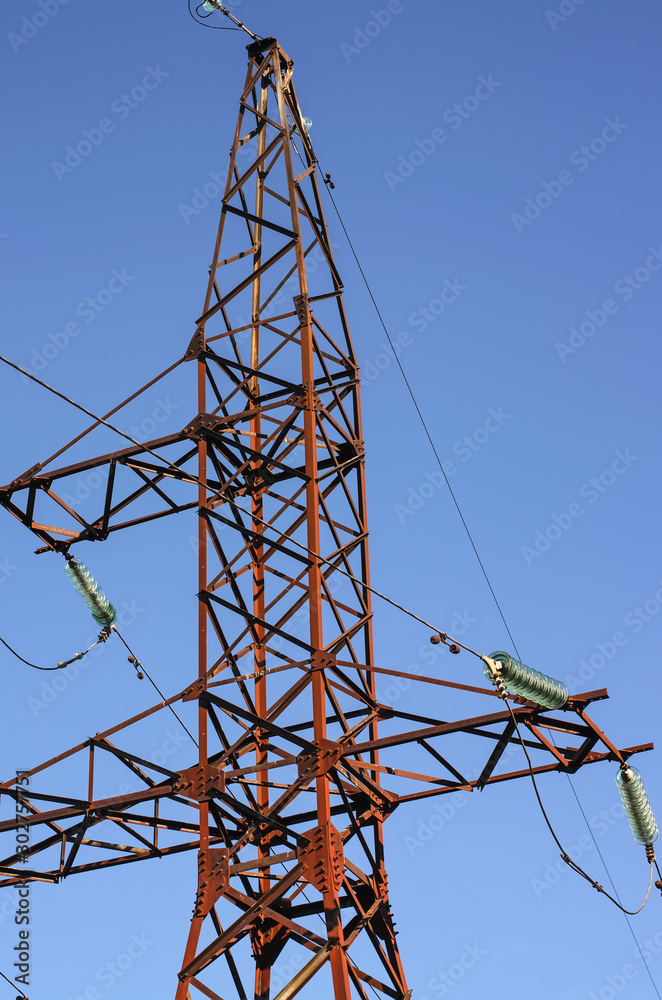 Wall mural fragment of old rusty electric power tower (high voltage), deep blue sky background, vertical shot