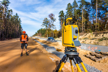 Surveyor engineer with equipment (theodolite or total positioning station) on the construction site...