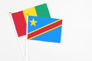 Congo and Guinea stick flags on white background. High quality fabric, miniature national flag. Peaceful global concept.White floor for copy space.