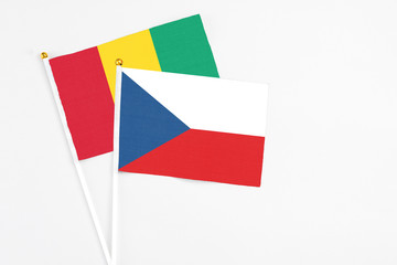 Czech Republic and Guinea stick flags on white background. High quality fabric, miniature national flag. Peaceful global concept.White floor for copy space.