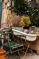 Garden chair and old bath with dry flowers