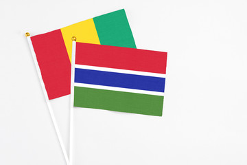 Gambia and Guinea stick flags on white background. High quality fabric, miniature national flag. Peaceful global concept.White floor for copy space.