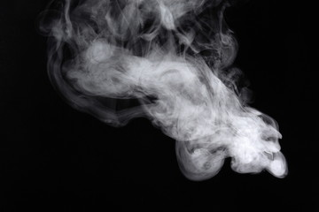 Puffs of white, gray smoke spread on a black background, curling in a fancy dance.