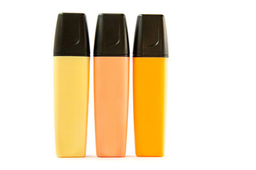 Tree soft-tip markers of yellow and orange colors standing near each other isolated on white background..