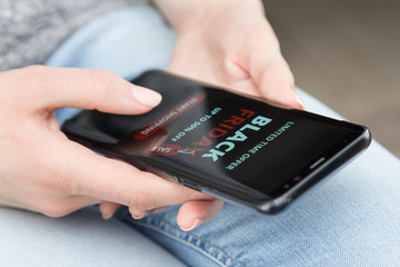 girl with a mobile phone in her hands makes purchases online on black Friday