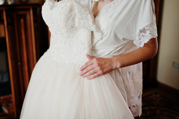 Elegant white wedding dress at bride morning on hands.