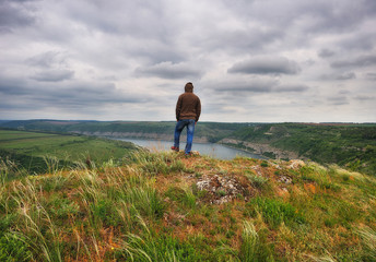tourist on the rock. a man stands over a canyon of a picturesque river