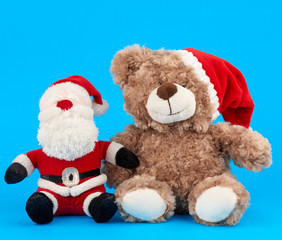 little teddy bear in red christmas hat and santa claus