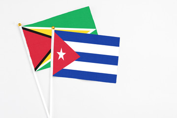 Cuba and Guyana stick flags on white background. High quality fabric, miniature national flag. Peaceful global concept.White floor for copy space.