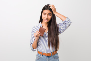 Young arab woman holding a wallet being shocked, she has remembered important meeting.