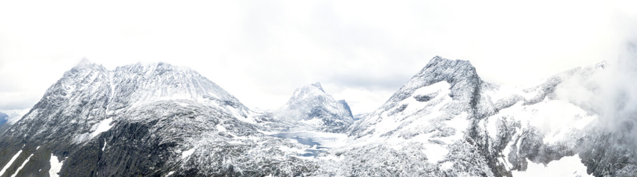 Aerial panoramic of Store Venjetinden and Olaskarstinden mountains covered with snow, Venjesdalen valley, Romsdalen, Rauma