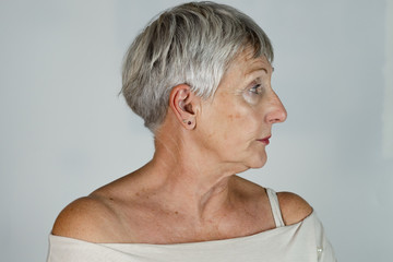 older White haired woman with White t shirt in profile on White background