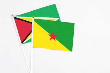 French Guiana and Guyana stick flags on white background. High quality fabric, miniature national flag. Peaceful global concept.White floor for copy space.