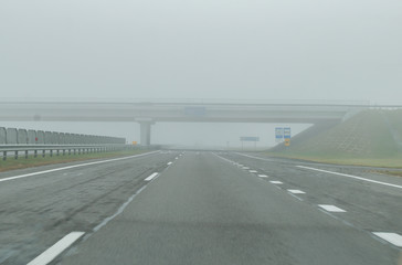 Road bridge across the road in the fog