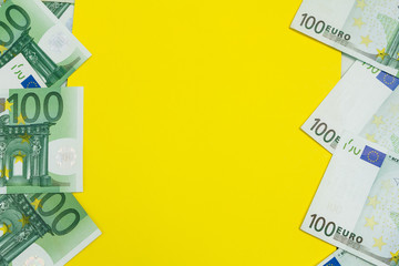 Many Banknotes of 100 Euro with yellow copy space, the European currency background flat lay