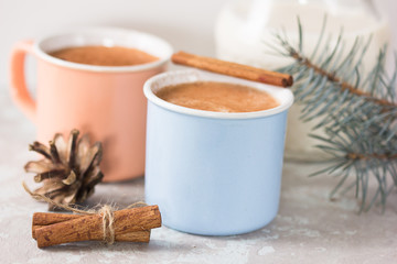 Christmas holiday cacao. Hot chocolate cacao drinks with decoration  in Christmas mugs on grey background. Traditional hot beverage, festive cocktail at X-mas or New Year
