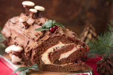 Chocolate yule log christmas cake on wooden background.