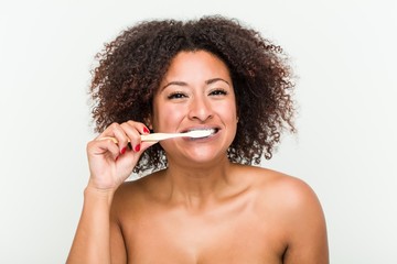 Close up of a young african american woman brushing her teeth with a toothbrush