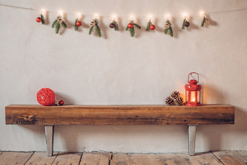Cozy rustic Christmas composition in a rural house with a lantern and red bauble on an old wooden log