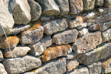 Stone wall. Abstract dry stones in boundary wall in Derbyshire Peak District countryside.  Stone material construction, natural and textured.