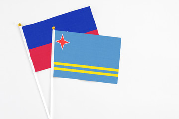Aruba and Haiti stick flags on white background. High quality fabric, miniature national flag. Peaceful global concept.White floor for copy space.