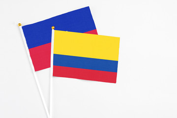 Colombia and Haiti stick flags on white background. High quality fabric, miniature national flag. Peaceful global concept.White floor for copy space.