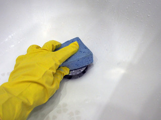 Photo hands in a bright rubber glove washing sponge home plumbing, close-up. Housework and maintenance of cleanliness is the main concept of maintenance.