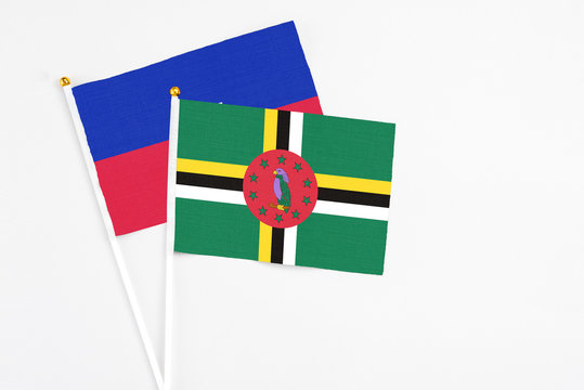 Dominica and Haiti stick flags on white background. High quality fabric, miniature national flag. Peaceful global concept.White floor for copy space.