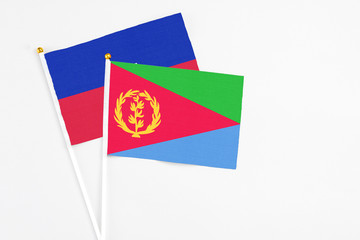 Eritrea and Haiti stick flags on white background. High quality fabric, miniature national flag. Peaceful global concept.White floor for copy space.