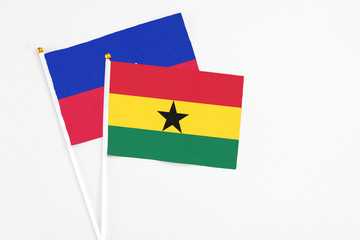 Ghana and Haiti stick flags on white background. High quality fabric, miniature national flag. Peaceful global concept.White floor for copy space.