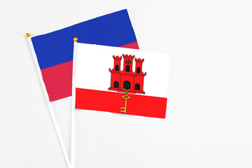 Gibraltar and Haiti stick flags on white background. High quality fabric, miniature national flag....