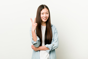 Young asian woman showing number two with fingers.