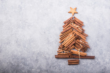 Christmas tree made of cinnamon on grey background, space for text. X-mas or New year festive flat lay background